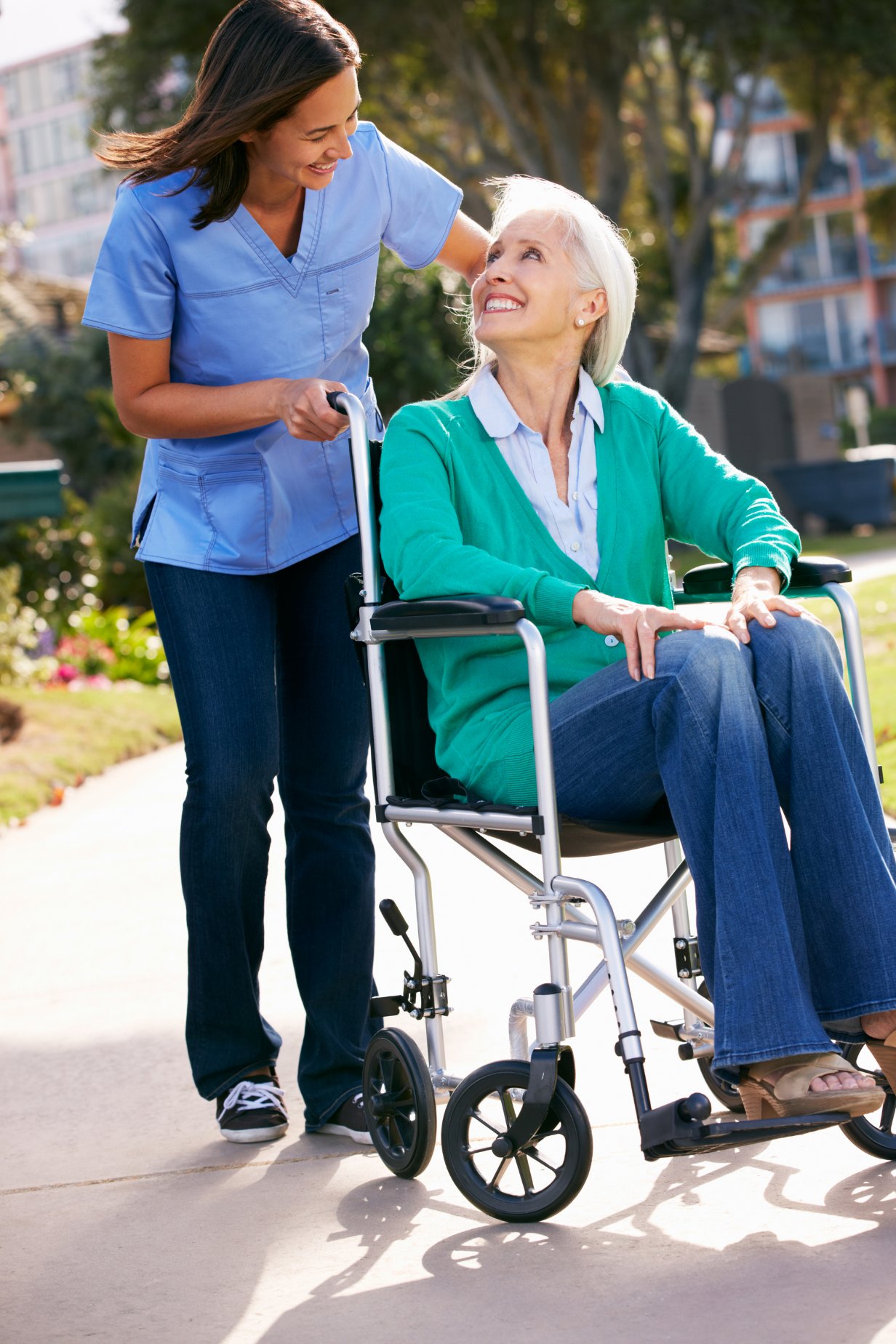 A carer walking with a client in a wheelchair