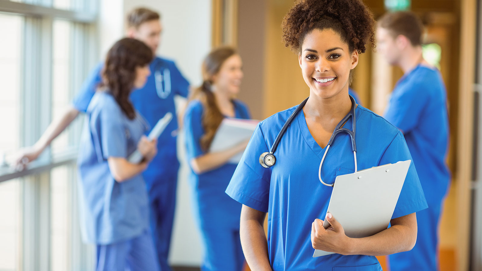 A smiling care professional holding a clipboard