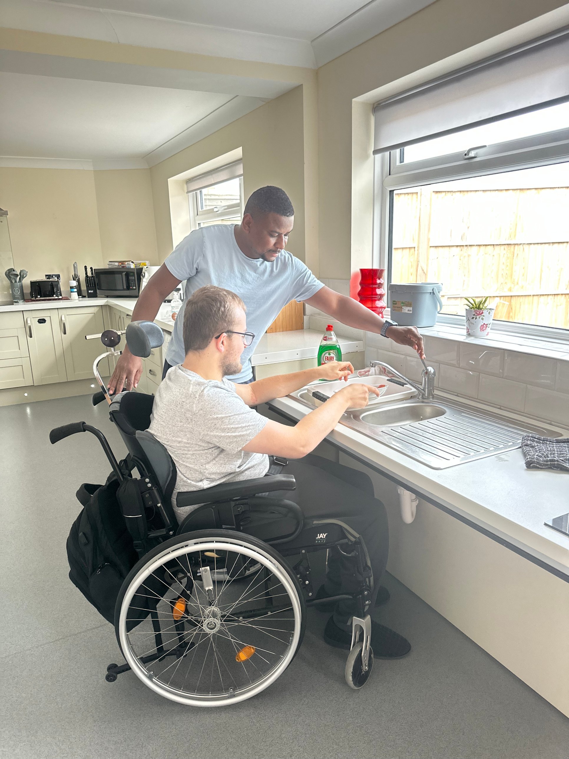 A SAP Care support worker helping with the washing up