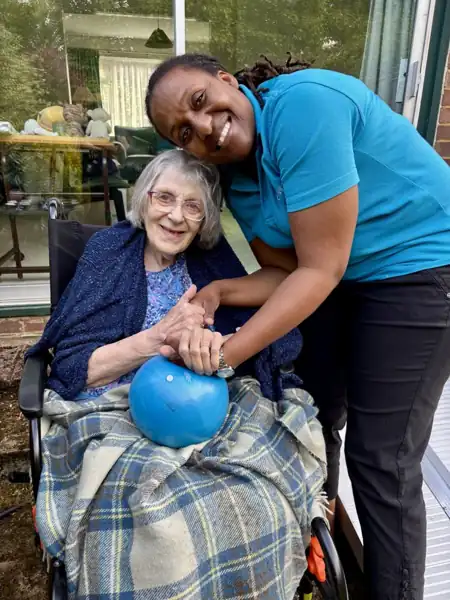 A smiling SAP Care carer with a client in her garden
